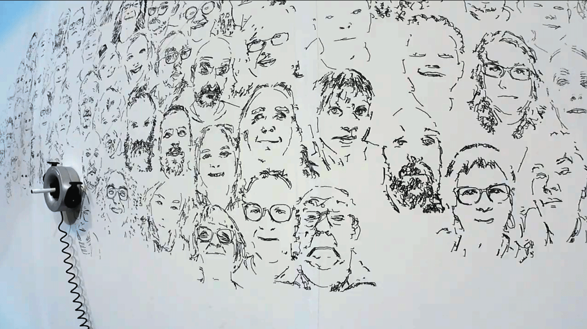 Lots of drawn faces and a robotic wall drawing machine drawing them.