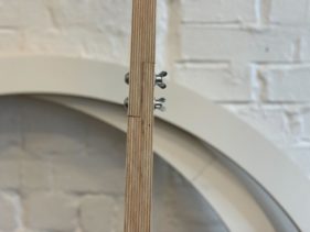 A close up of wooden bars that function as pendulums in Kaleider's artwork Harmonograph.